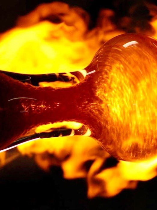 Fat Graffix hand pipe glowing in the flame while red frit is worked in
