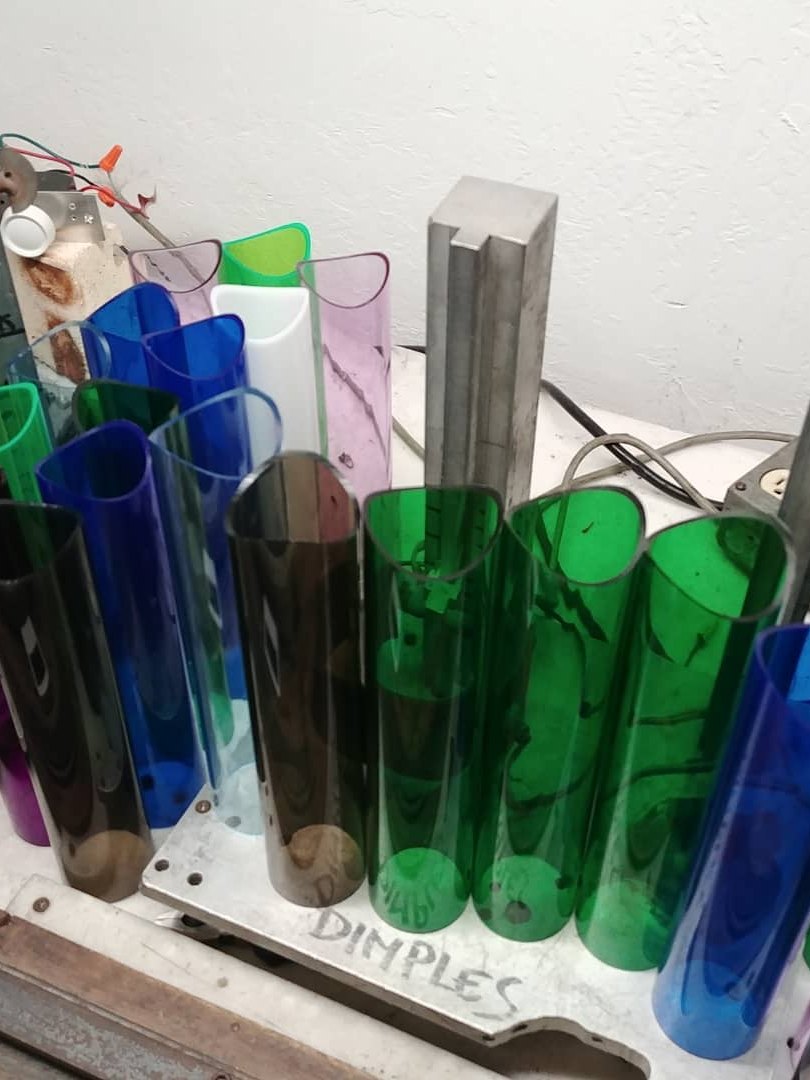 Cut blue, green and purple acrylic tubes in the Phoenix shop