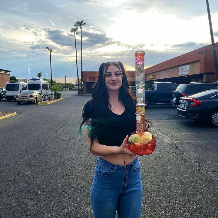 Customer holding a tall Graffix glass straight at sunset