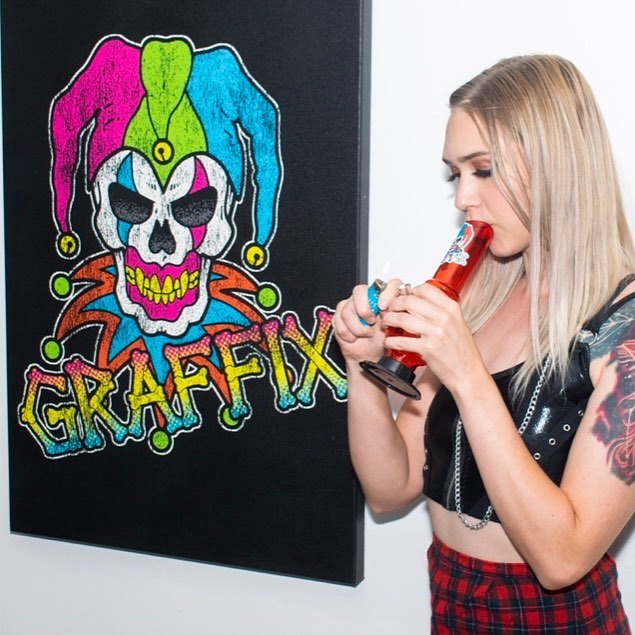 Woman with a red acrylic Graffix next to jester artwork