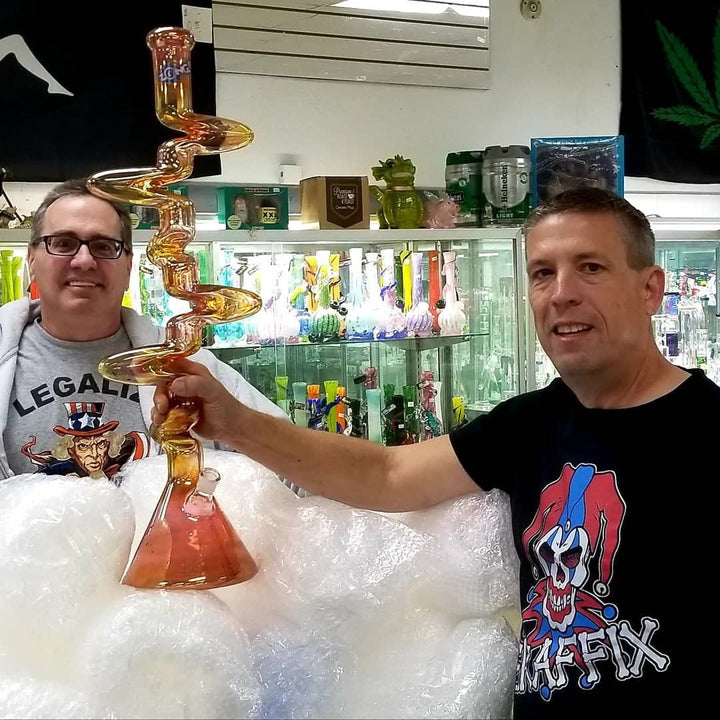 Smoke shop owners holding a Graffix glass piece